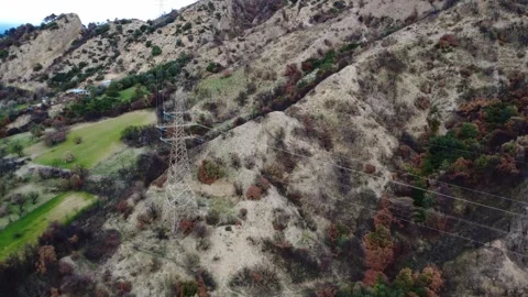 Wildfire damaged hillside crossed by high voltage power infrastructure Stock Footage 344095311