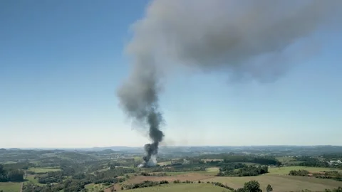 A wildfire in a field with smoke rising high in the sky. Aerial. 4K. Drone. Stock Footage 330982172