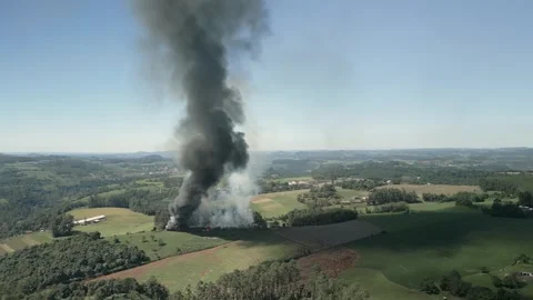 A wildfire in a field with smoke rising high in the sky. Aerial. 4K. Drone. Stock Footage 330982248