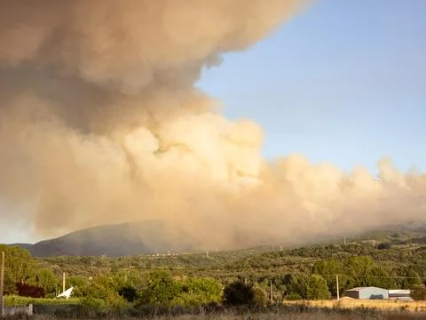Wildfire producing massive smoke cloud over landscape Stock Photos