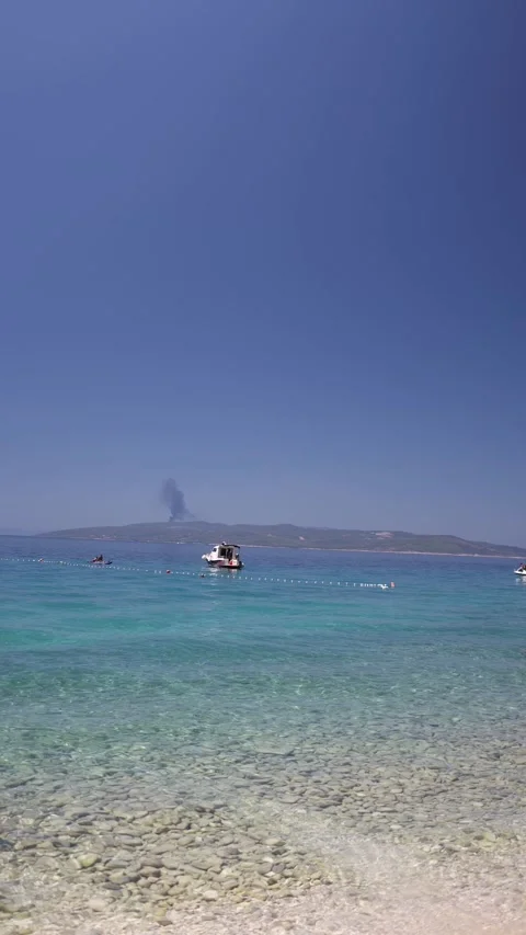 Wildfire smoke beyond calm turquoise coastal waters Stock Footage 341319405