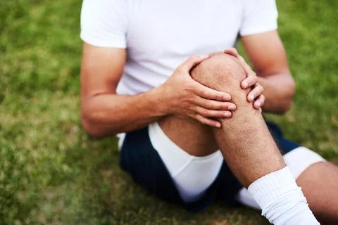 Will my physio be able to fix this. a man injuring his knee during a rugby game. Foto stock