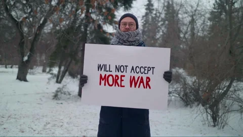 Will not accept more war. Male caucasian activist with a sign against war Stock Footage 132369636