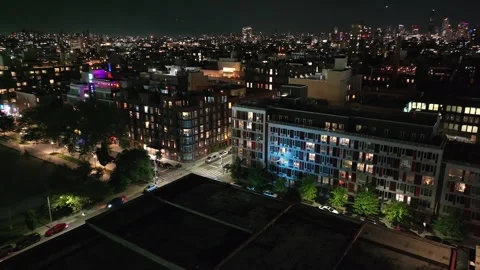 Williamsburg waterfront architecture glows beside East River at night Vídeo Stock 244256361