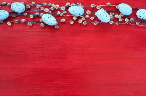 Willow branch and decorative Easter eggs on red background. Top view, copy space Stock Photos