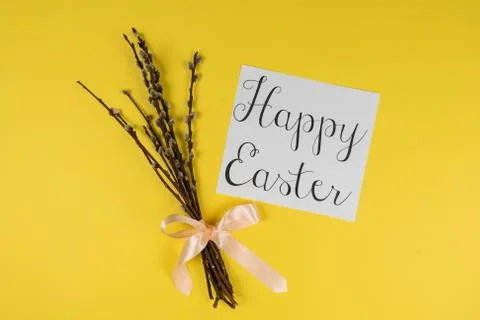Willow branches and Happy Ester greeting card isolated on yellow background Stock Photos