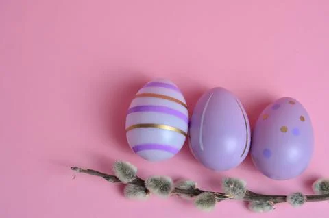 Willow twig and purple Easter eggs on a pink background. Stock Photos