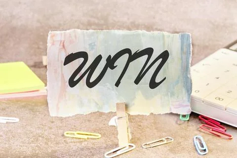 Win text on a piece of paper on the table with a clothespin clamped 스톡 사진