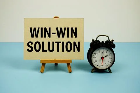 Win Win solution text on paper card with alarm clock on blue background Stock Photos