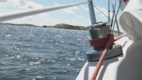 A winch on the railing of the deck of a white sailing boat at sea - slowmotion f 動画素材 119738174