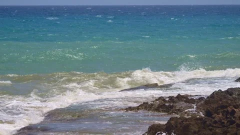 Wind and sun play on the coastline, with waves thrusting forward, creating .. Stock Footage 248595925