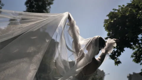 The wind beautifully winds the veil and the bride's white dress. Stock Footage 201626681