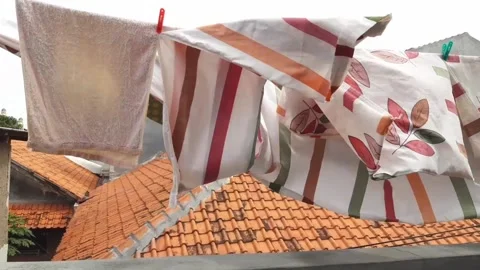 The wind blow the hanging laundry hard in daylight Stock Footage 221813766