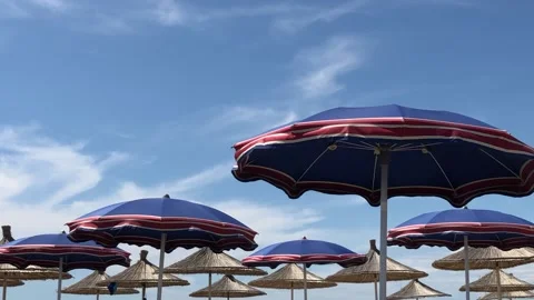 Wind blowing. Beach blue umbrellas at Adriatic sea in Albania,Durres Stock Footage 133342348