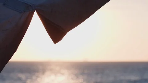 Wind blowing a beach structure in slow motion, lens flare over it Video stock 128011761