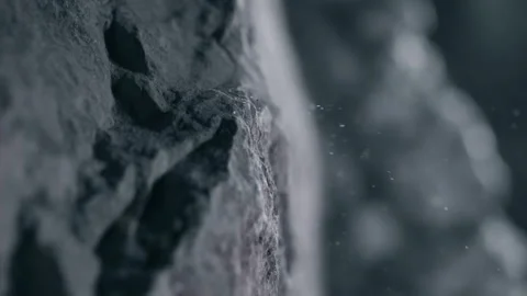 Wind is blowing dust and sand particles of a cliff in close up in slow motion Stock Footage 257318203