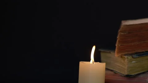 Wind Blowing Flame Of A White Candle with Old Books on Background 스톡 동영상 130519021