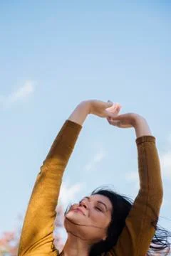 Wind blowing hair of Caucasian woman with arms raised Stock Photos