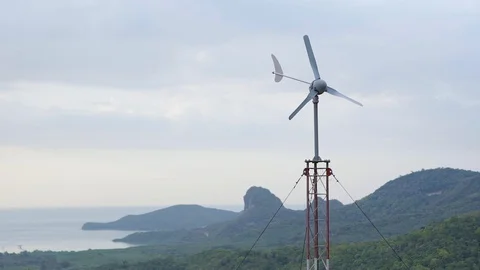 Wind blowing propeller to told direction's wind with green island Stock Footage 128675641