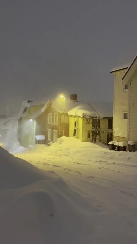 Wind blowing snow off roofs along a snowy street in Tromsø Video stock 302474355