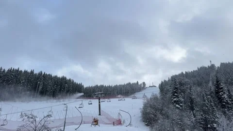 Wind blowing snow on ski slope with chair lifts Stock Footage 294378953