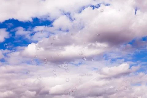 Wind Blowing Soap Bubbles Across Overcast Sky Stock Photos