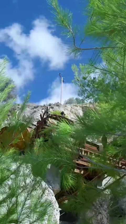 Wind blowing through pine tree branches by old mining equipment Stock-Footage 294963997