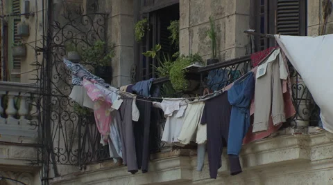 Wind-blown laundry hangs on old building balcony Stock Footage 39991878