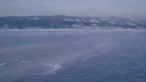 Wind blows and carries snowdrift across the frozen ice. bad weather in winter. Stock Footage 230463335