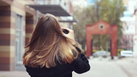 The wind blows the hair. view from the back of a girl tourist taking pictures Stock Footage 82502751