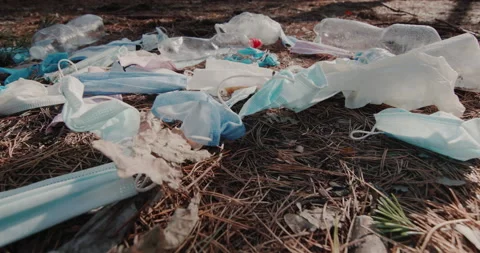 The wind blows on a pile of garbage from medical masks. Pollution of forests by Stock Footage 143802243