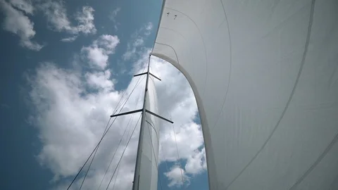 The wind blows into the sails of the yacht which goes through the water against Video stock 108169195