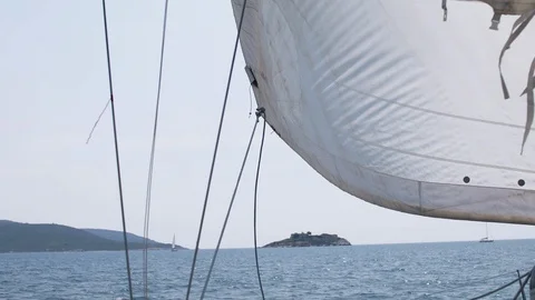 The wind blows into the sails of the yacht which goes through the water against Stock Footage 108601998