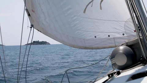 The wind blows into the sails of the yacht which goes through the water against Stock Footage 108603512