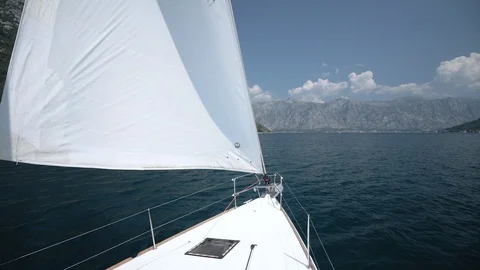 The wind blows into the sails of the yacht which goes through the water against Stock Footage 108605431