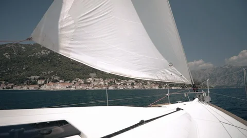 The wind blows into the sails of the yacht which goes through the water against Stock Footage 108610644