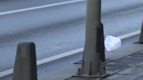 The wind carries a plastic bag on the sidewalk. Stock Footage 150211669