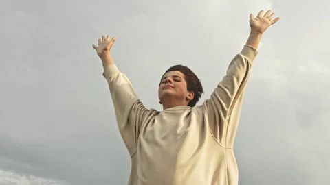 Wind catcher. Slow motion Stylish teenager boy stands in the strong wind with Stock Footage 242143994