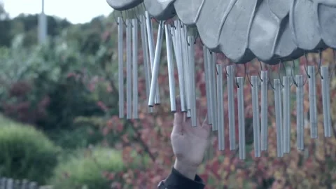 Wind chime being struck by a child, slow motion Stock Footage 219105795