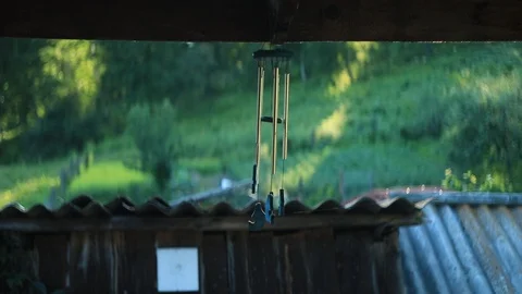 Wind chime with cobwebs hanging on the porch of an old village house Stock Footage