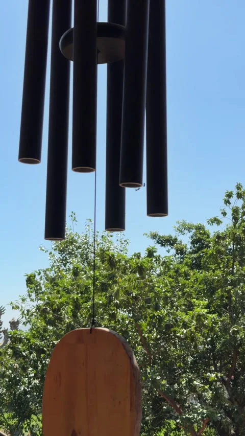 Wind chime oscillates in front of a multi tier pagoda structure, emphasizing Stock Footage 330061693