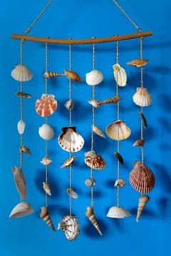 A wind chime with shells on a blue background Stock Photos