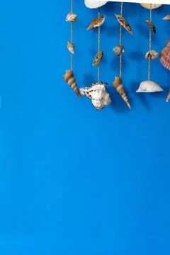 A wind chime with shells on a blue background Stock Photos