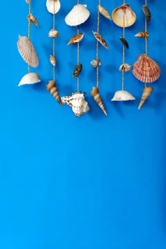 A wind chime with shells on a blue background Stock Photos