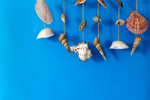 A wind chime with shells on a blue background Stock Photos