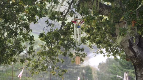 Wind chimes in a tree on a rainy day Stockbeeldmateriaal 153948876