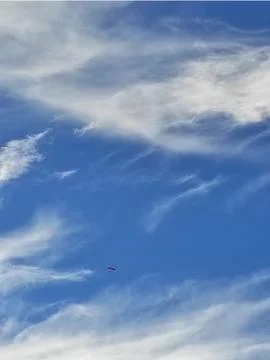Wind clouds over blue blanket of sky Foto stock