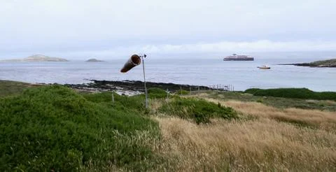 Wind cone in rough and windy grass landscape with cruise ship, Falkland Islands Stock Photos