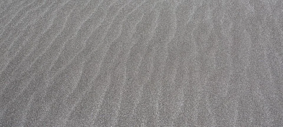 Wind creating patterns on beach sand texture background Stock Photos