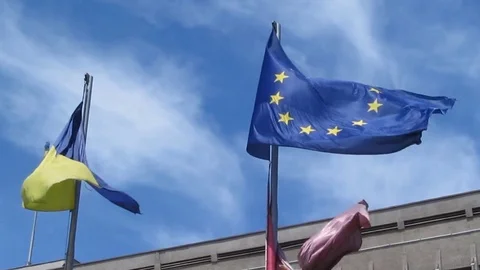 The wind develops flags of Ukraine and the European Union in the blue sky - 34s Video stock 77609876